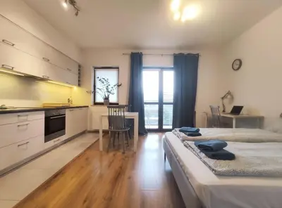a bedroom with two beds and a kitchen with a table at Śliczna 34A by Homeprime in Kraków