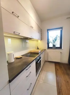 a kitchen with white cabinets and a sink and a window at Śliczna 34A by Homeprime in Kraków