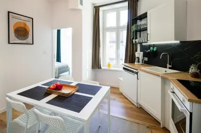 a kitchen with a table with a bowl of fruit on it at WAWELOVE Piłsudskiego - 3 bedroom apt. with balcony and free parking! in Kraków