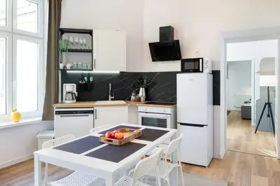 a kitchen with a table with a bowl of fruit on it at WAWELOVE Piłsudskiego - 3 bedroom apt. with balcony and free parking! in Kraków