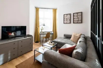 a living room with a couch and a television at WAWELOVE Piłsudskiego - 3 bedroom apt. with balcony and free parking! in Kraków