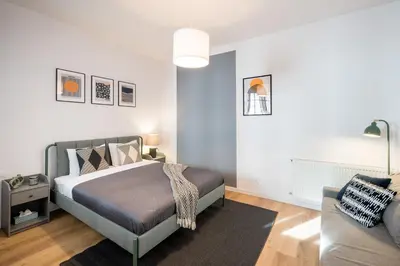 a bedroom with a bed and a couch at WAWELOVE Piłsudskiego - 3 bedroom apt. with balcony and free parking! in Kraków