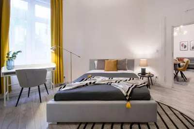 a bedroom with a bed and a desk in it at WAWELOVE Piłsudskiego - 3 bedroom apt. with balcony and free parking! in Kraków