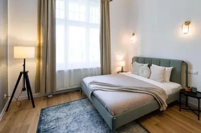 a bedroom with a bed and a large window at WAWELOVE Piłsudskiego - 3 bedroom apt. with balcony and free parking! in Kraków