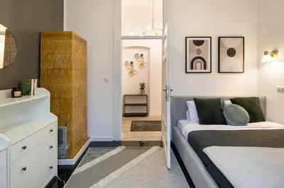 a small bedroom with a bed and a closet at WAWELOVE Piłsudskiego - 3 bedroom apt. with balcony and free parking! in Kraków