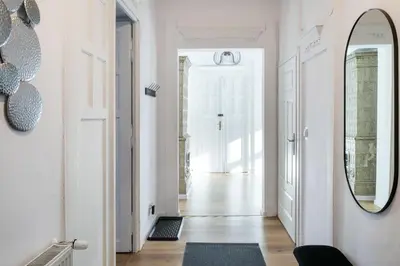 a hallway with white walls and a mirror at WAWELOVE Piłsudskiego - 3 bedroom apt. with balcony and free parking! in Kraków