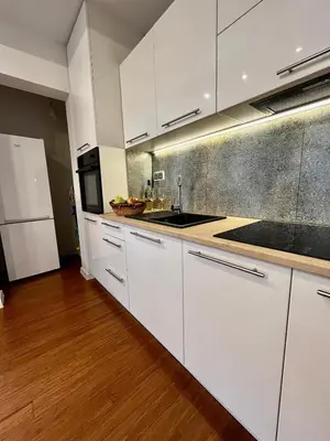 a kitchen with white cabinets and a sink at Mała Góra Apartment in Kraków