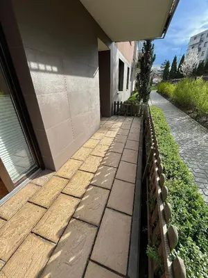 a stone walkway next to a building with a building at Mała Góra Apartment in Kraków