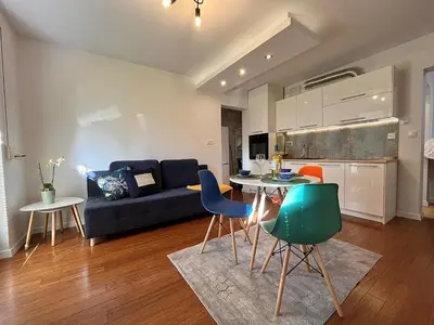 a living room with a couch and a table and chairs at Mała Góra Apartment in Kraków
