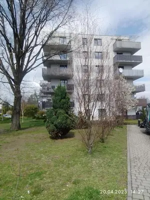 a apartment building with a grassy yard in front of a building at Mała Góra Apartment in Kraków