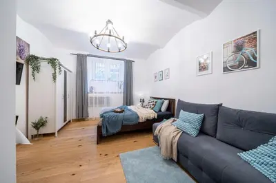 a living room with a couch and a bed at St. Miasto Studio Kraków in Kraków