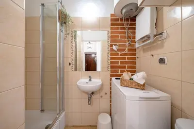 a bathroom with a sink and a toilet and a shower at St. Miasto Studio Kraków in Kraków