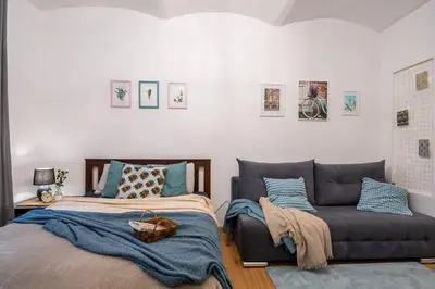 a bedroom with two beds and a couch at St. Miasto Studio Kraków in Kraków