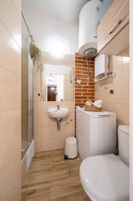 a small bathroom with a toilet and a sink at St. Miasto Studio Kraków in Kraków