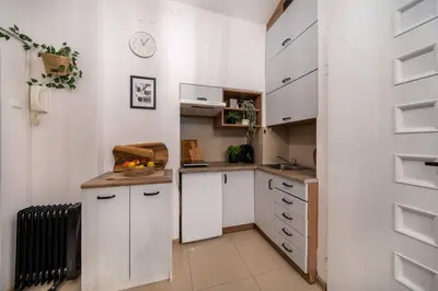 a small kitchen with white cabinets and a counter at St. Miasto Studio Kraków in Kraków