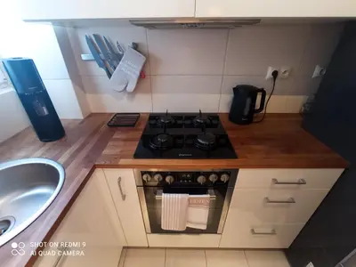 a small kitchen with a stove and a sink at Apartament boBoski in Wadowice