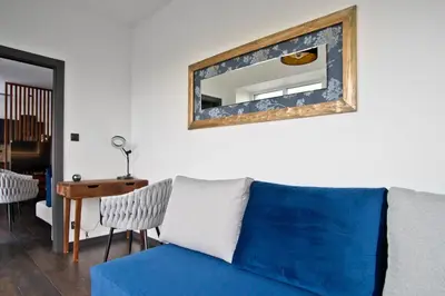 a blue couch in a living room with a mirror at Near Sanktuarium Beautiful View and Free Parking in Kraków