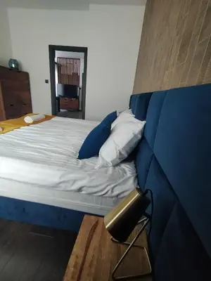 a bedroom with a bed with a blue head board at Near Sanktuarium Beautiful View and Free Parking in Kraków