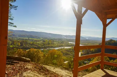a view from the porch of a cabin with the sun shining at Domki Na Winnicy - Winnica Talaska in Melsztyn
