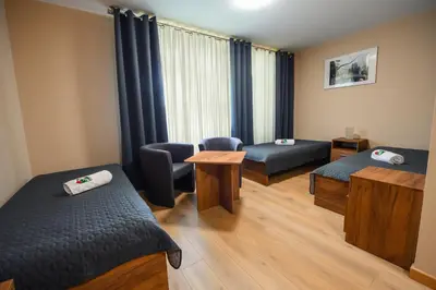 a room with two beds and chairs and a window at Pokoje Gościnne MODR in Karniowice