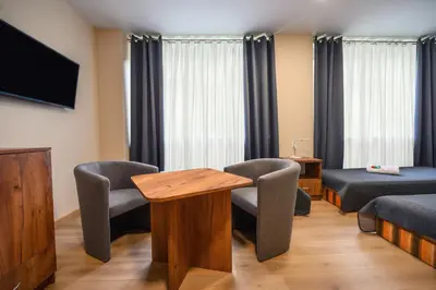 a room with two beds and a table and chairs at Pokoje Gościnne MODR in Karniowice