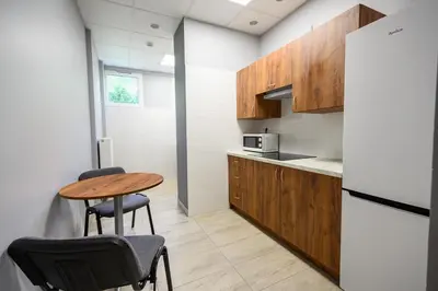 a kitchen with a table and chairs and a refrigerator at Pokoje Gościnne MODR in Karniowice