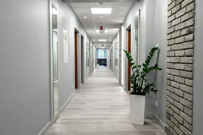 a corridor of an office with white walls and a brick wall at Pokoje Gościnne MODR in Karniowice