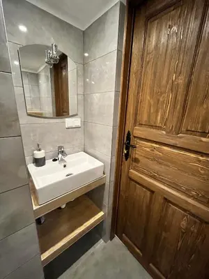 a bathroom with a sink and a wooden door at MATOGÓWKA in Krzeszowice