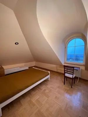 a bedroom with a bed and a chair and a window at Rezydencja Pod Platanem in Smardzowice