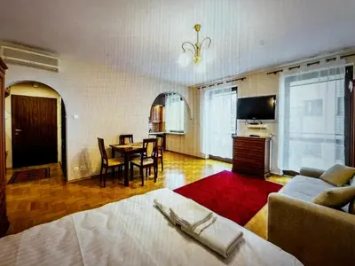 a living room with a bed and a dining room at Krupnicza Apartment in Kraków