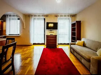 a living room with a couch and a red rug at Krupnicza Apartment in Kraków