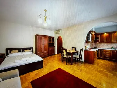 a bedroom with a bed and a table and a kitchen at Krupnicza Apartment in Kraków