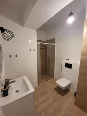 a bathroom with a sink and a shower and a toilet at Nest Niebieski in Zator