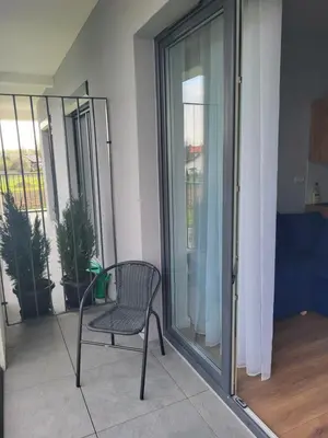 a chair sitting on a balcony in a room with glass doors at Nest Niebieski in Zator