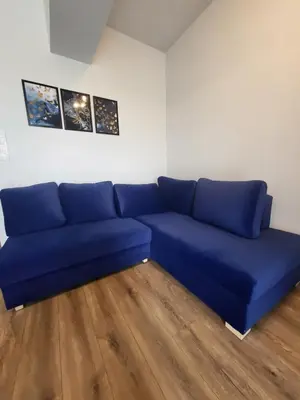 a blue couch in a room with a wooden floor at Nest Niebieski in Zator