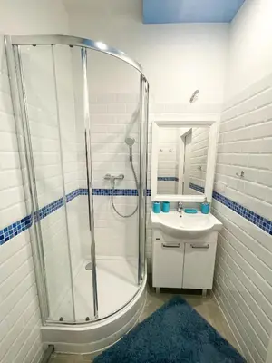 a white bathroom with a shower and a sink at Solne Apartamenty Luna in Wieliczka