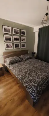 a large bed in a bedroom with pictures on the wall at Przytulne mieszkanie w Olkuszu/ Cosy apartment in Olkusz in Olkusz