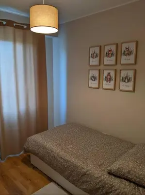 a bedroom with a bed and four pictures on the wall at Przytulne mieszkanie w Olkuszu/ Cosy apartment in Olkusz in Olkusz