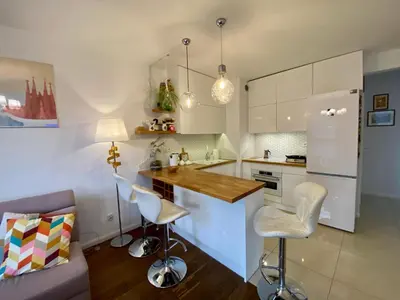 a living room with a purple couch and a table at White and Bright Riverside View Flat with Parking, Bike Access, and Onsite Gym in Kraków