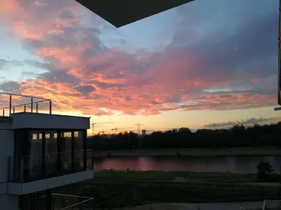 a balcony of a building with a view of a park at White and Bright Riverside View Flat with Parking, Bike Access, and Onsite Gym in Kraków