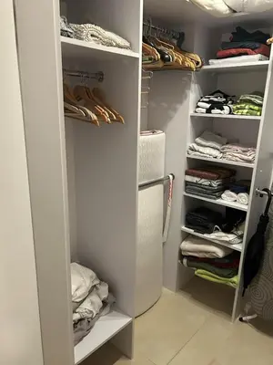 a kitchen with white cabinets and a wooden counter top at White and Bright Riverside View Flat with Parking, Bike Access, and Onsite Gym in Kraków