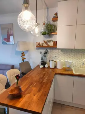 a balcony with a table and a view of a lake at White and Bright Riverside View Flat with Parking, Bike Access, and Onsite Gym in Kraków