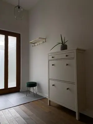 a white dresser with a plant on top of it in a room at D7 Apartment in Kraków