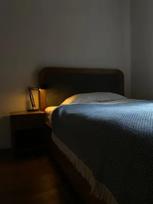 a bedroom with a bed and a lamp on a night stand at D7 Apartment in Kraków