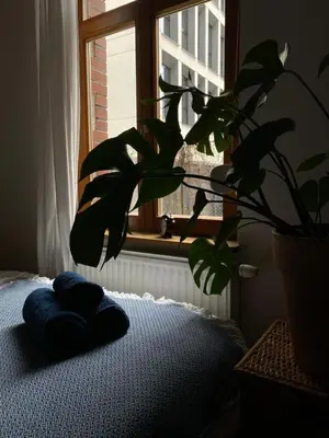 a blue pillow on a bed next to a window at D7 Apartment in Kraków