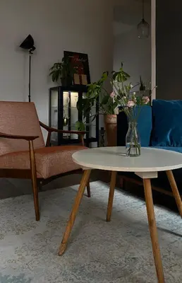 a living room with a table with a vase of flowers on it at D7 Apartment in Kraków