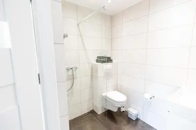 a white bathroom with a toilet and a shower at Modern House in Old Town Numero 5 in Kraków