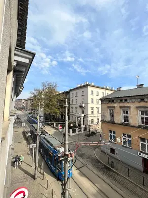 a train on a track in a city with buildings at Modern House in Old Town Numero 5 in Kraków