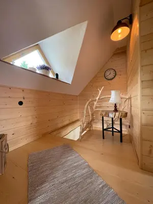 a room with wood paneling and a staircase in a house at Gliniana Chata in Zawoja