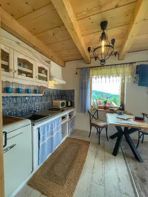 a kitchen with a table and a dining room at Gliniana Chata in Zawoja